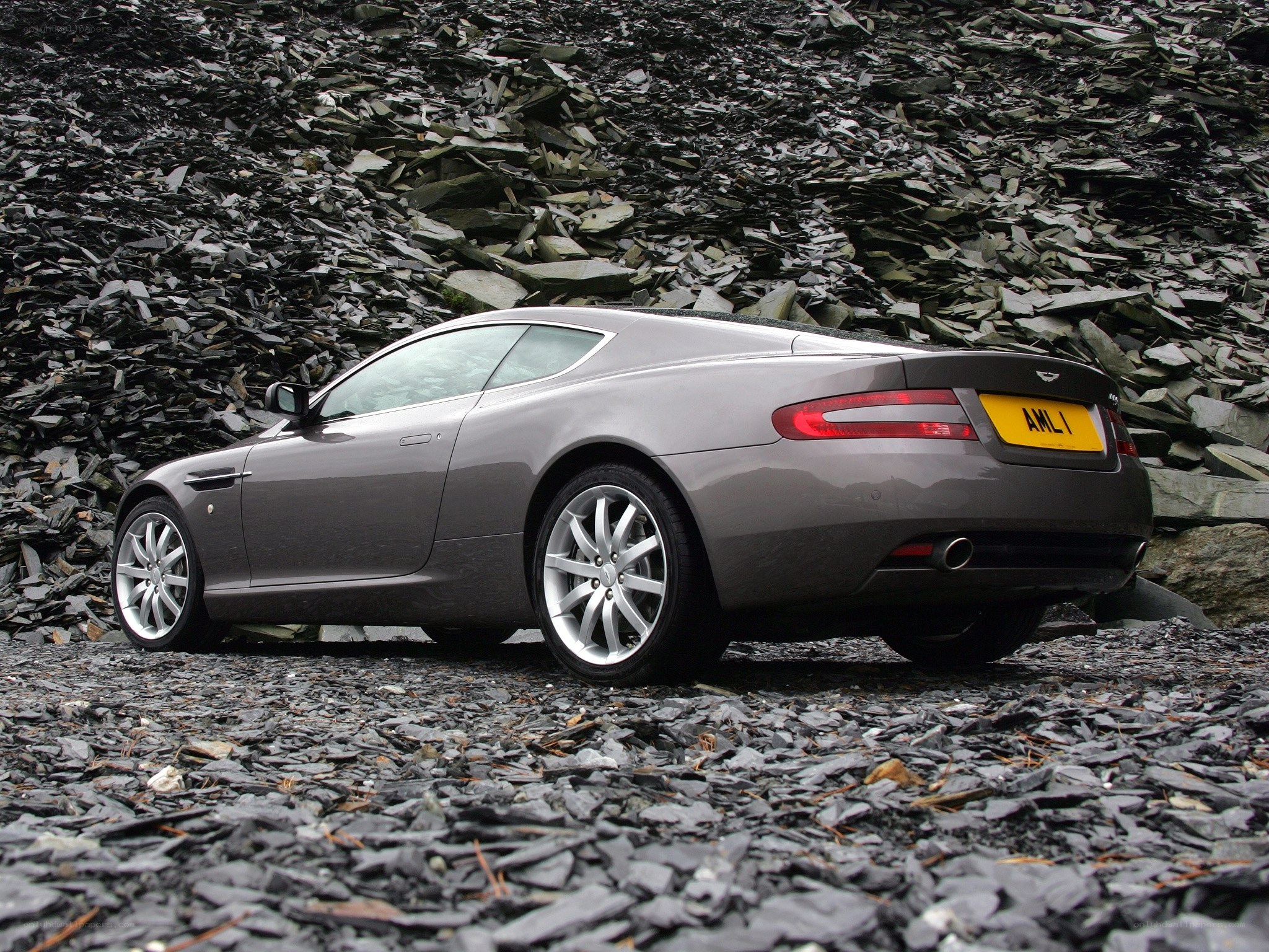 Gray Aston Martin on rocky terrain