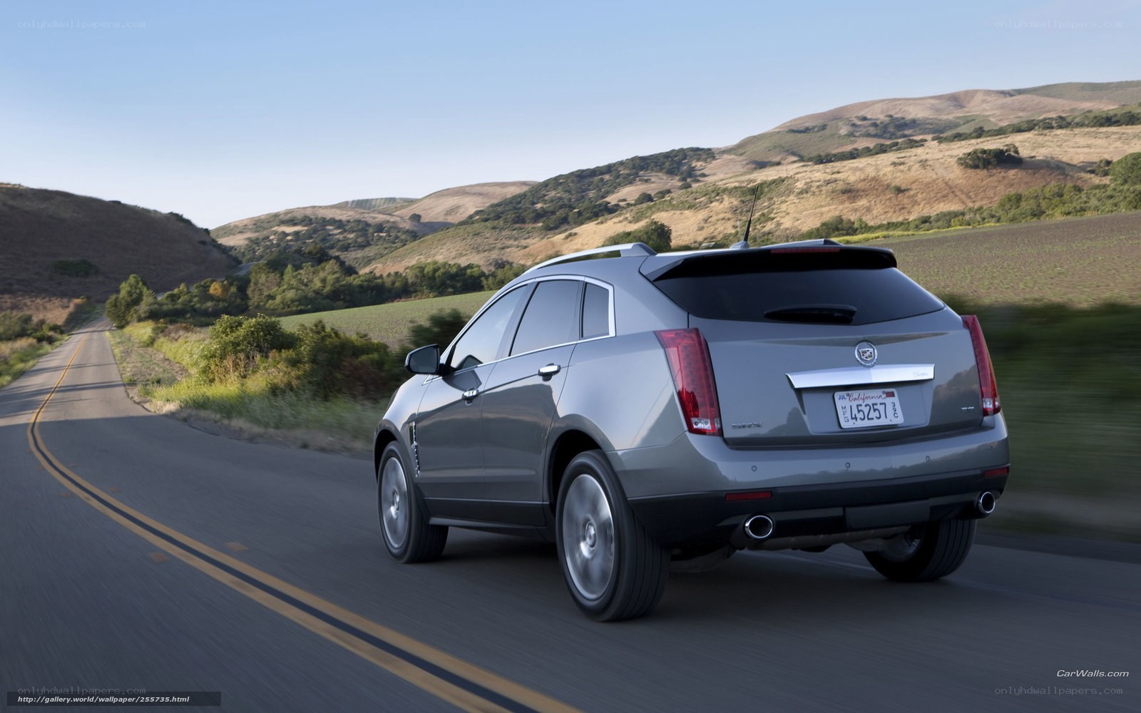gray cadillac suv on country road