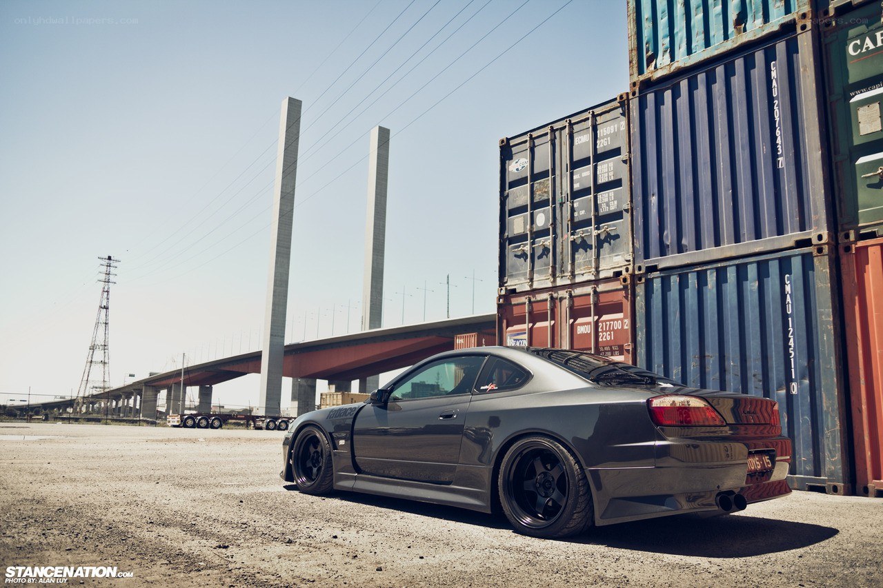 Gray car near shipping containers