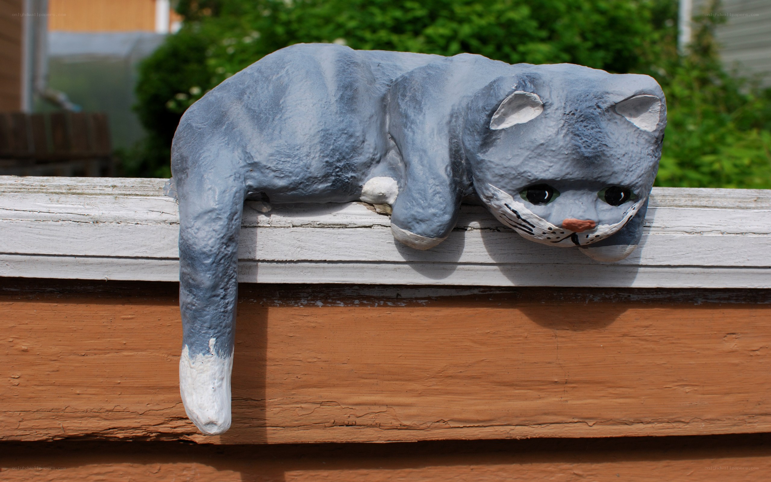 gray cat sculpture on fence