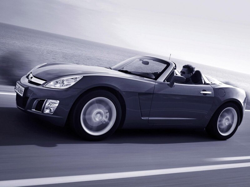 Gray convertible driving on coastal road