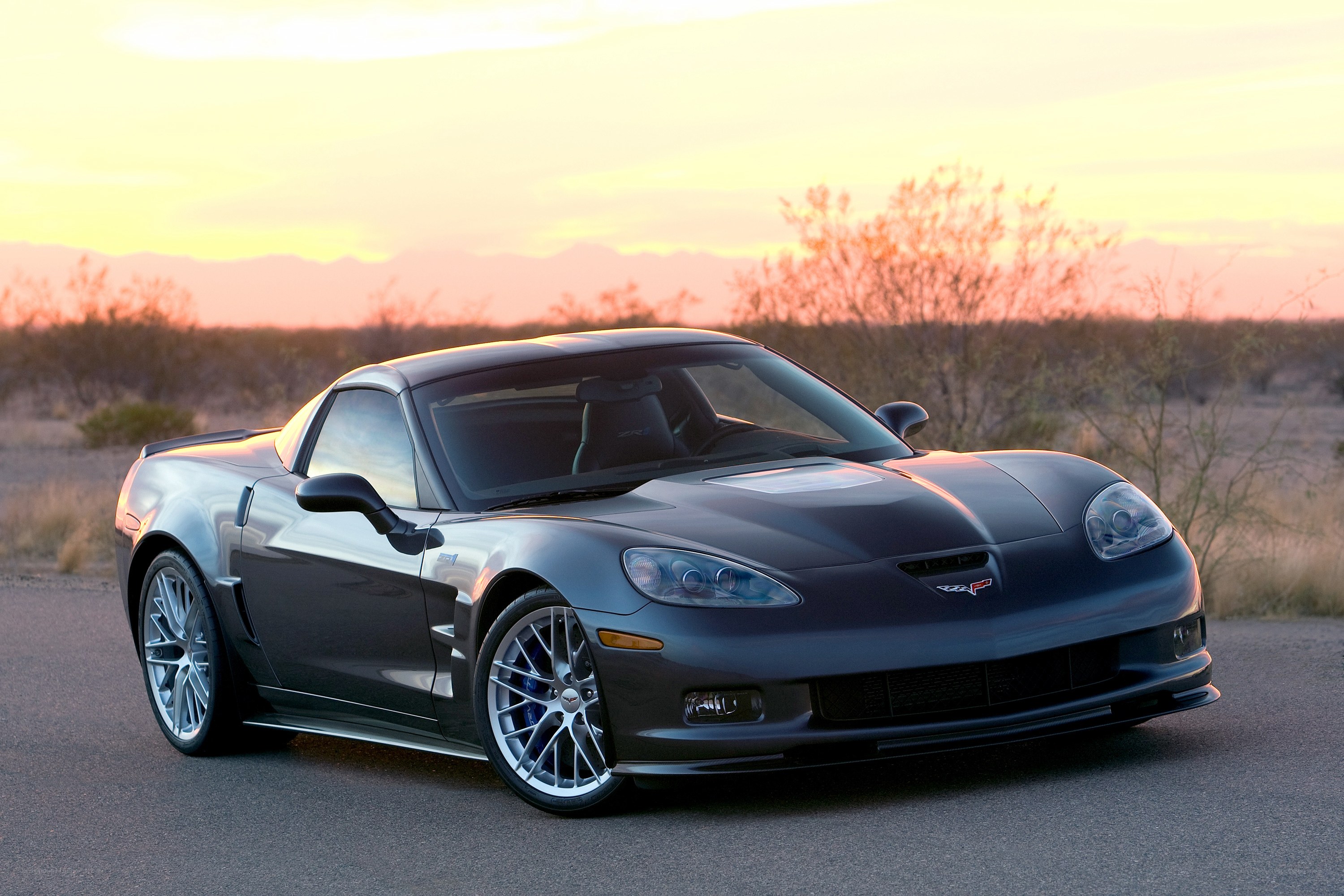 Gray Corvette in desert at sunset