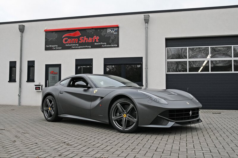 Gray Ferrari F12 parked outside a shop