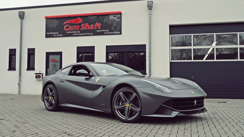 Gray Ferrari F12 parked outside shop