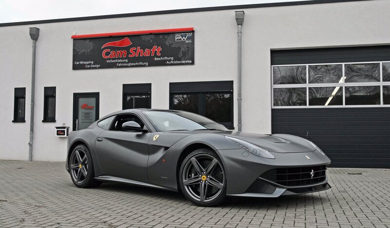 Gray Ferrari F12 parked outside shop