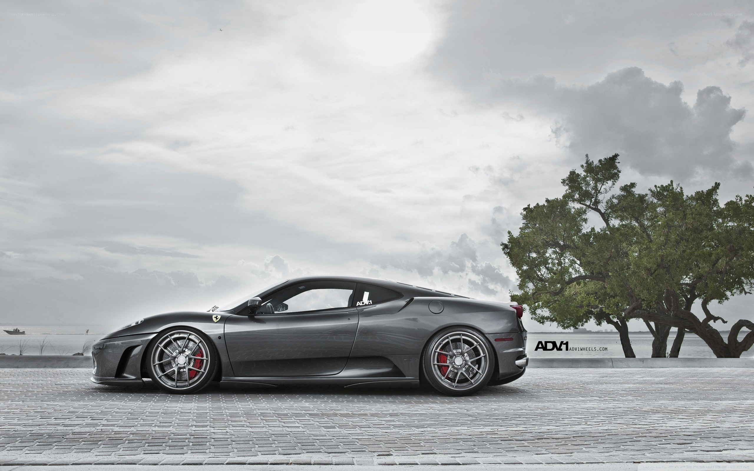 Gray Ferrari on a cobblestone pier