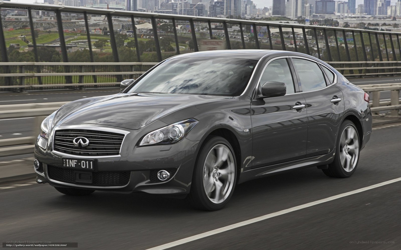 Gray Infiniti driving on bridge