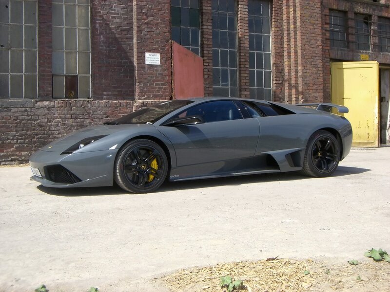 Gray Lamborghini in front of brick building