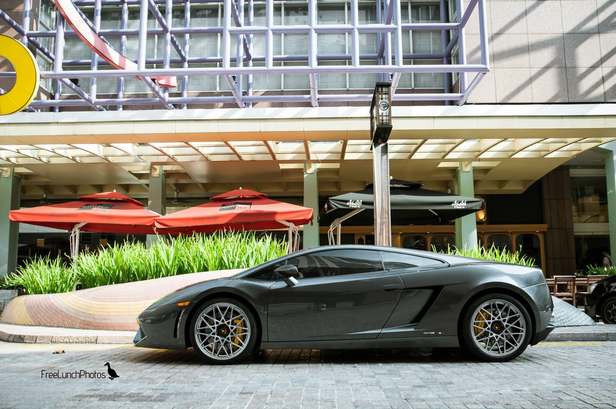 Gray Lamborghini parked outside restaurant