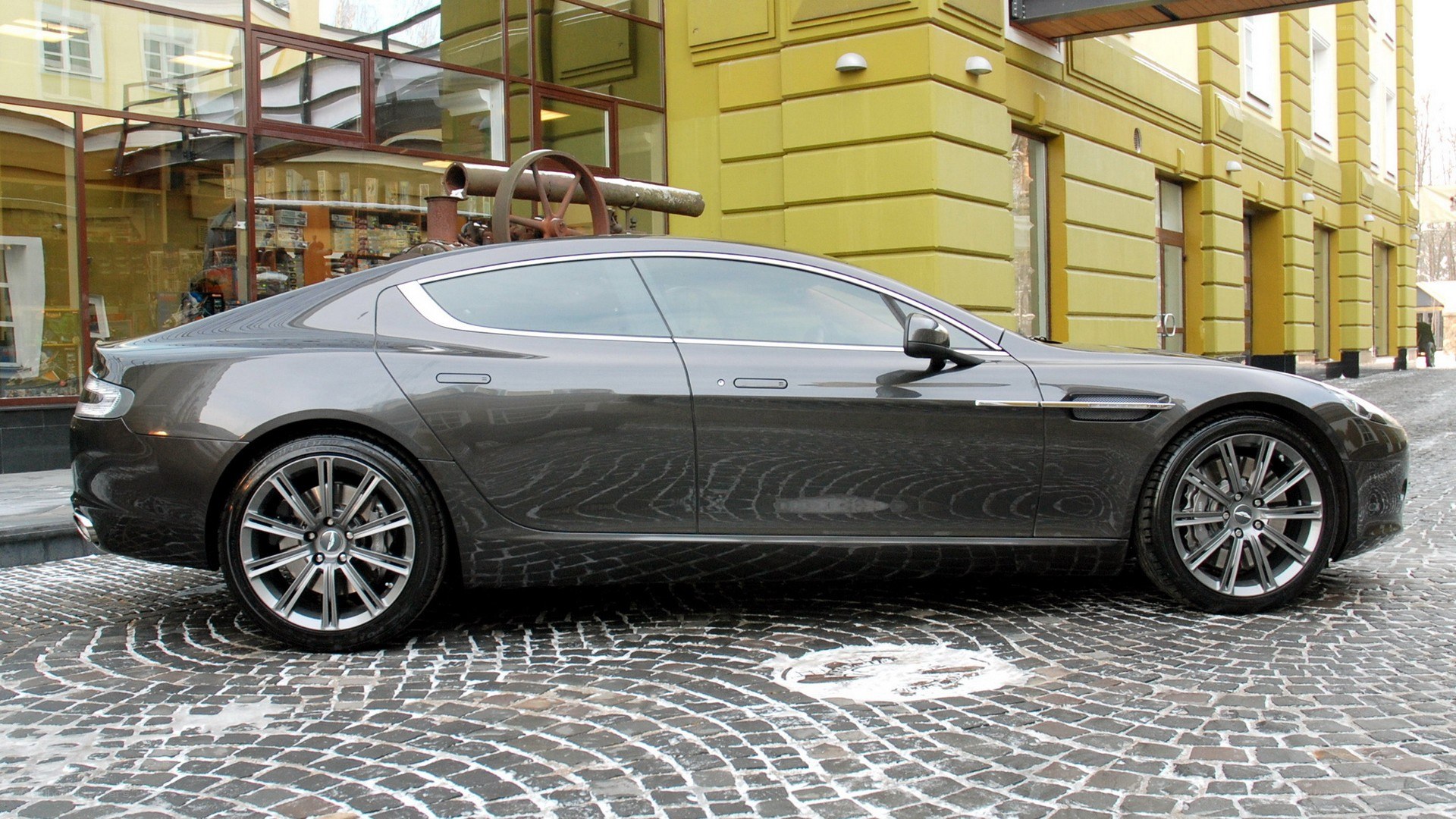 gray luxury car on cobblestone street