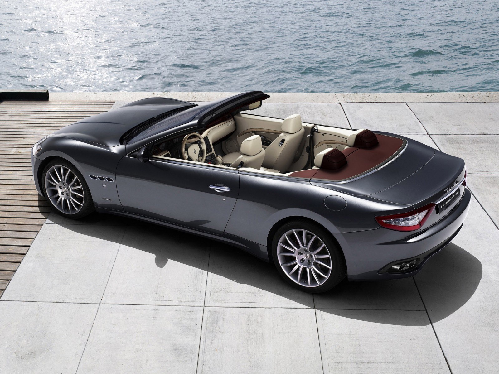 Gray Maserati convertible by the water