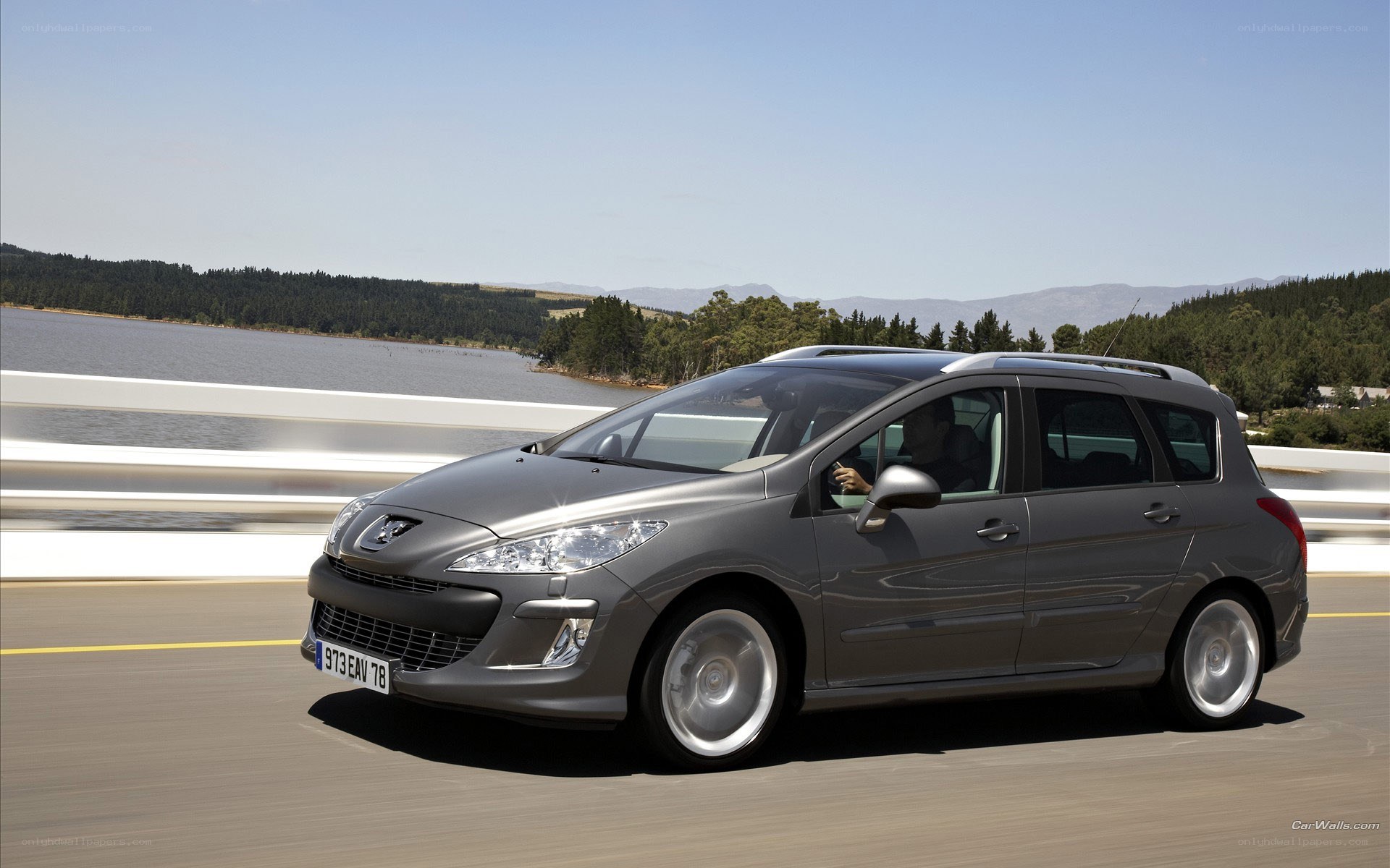 gray peugeot driving on bridge