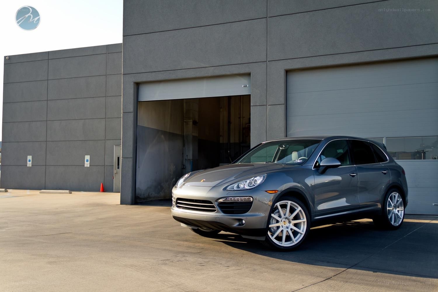 Gray Porsche Cayenne parked outside garage