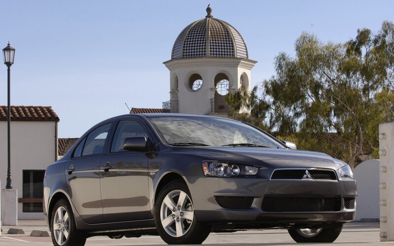 Gray sedan in front of a building