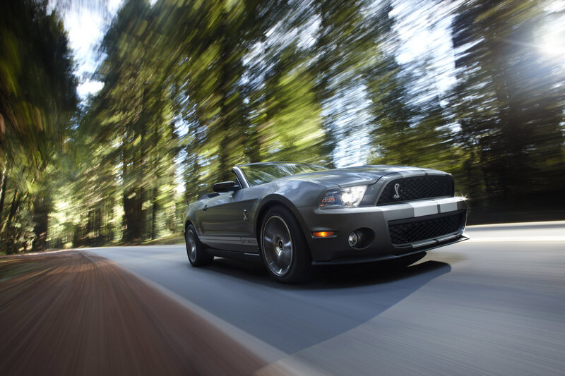 Gray Shelby convertible on forest road