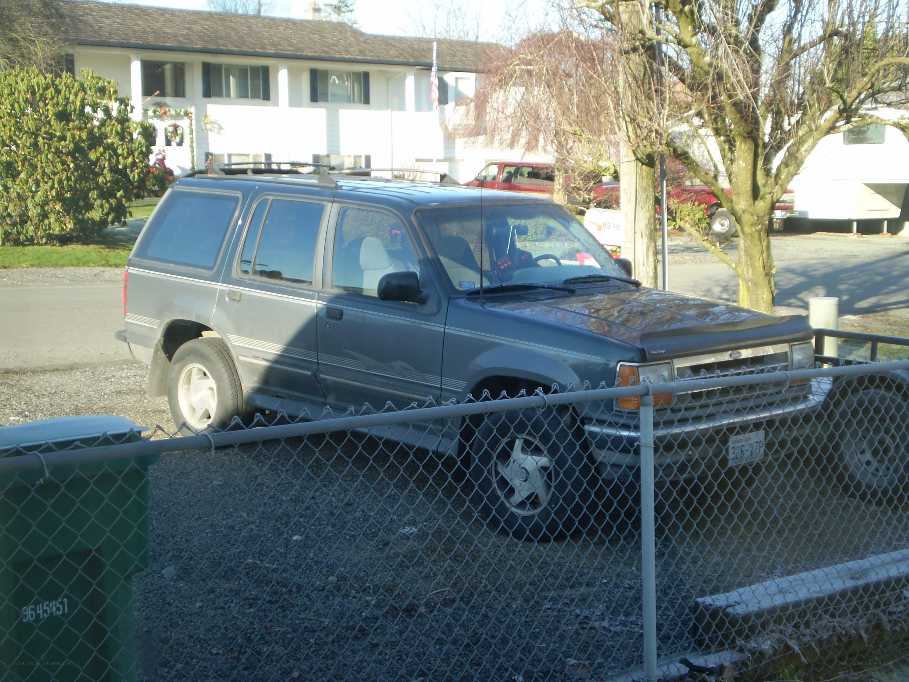 gray suv behind chain-link fence