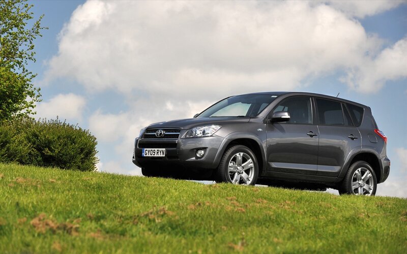 Gray Toyota RAV4 on a grassy hill
