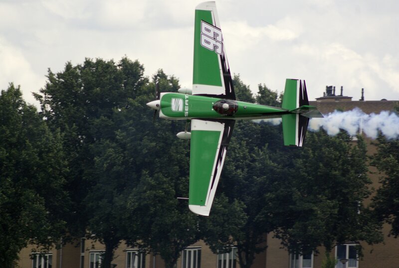green aerobatic plane in flight