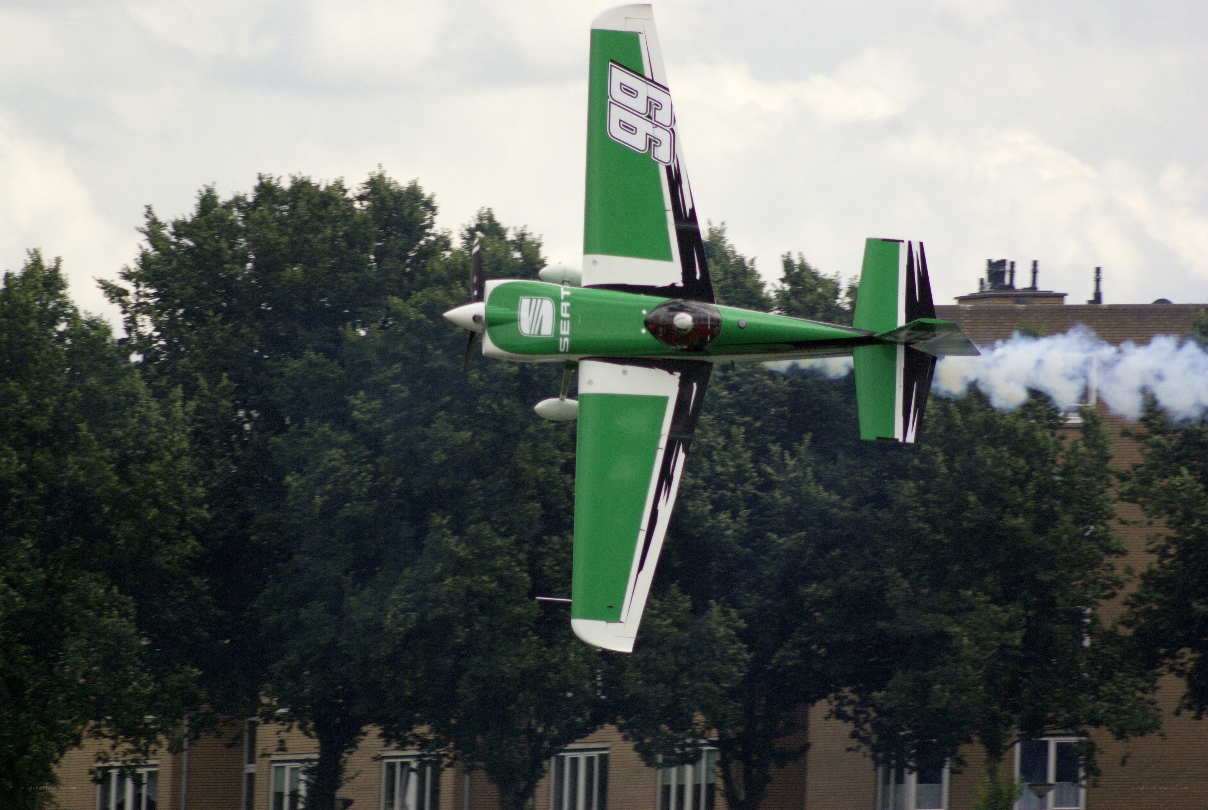 green aerobatic plane in flight
