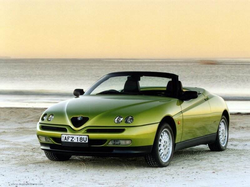 green alfa romeo convertible on beach