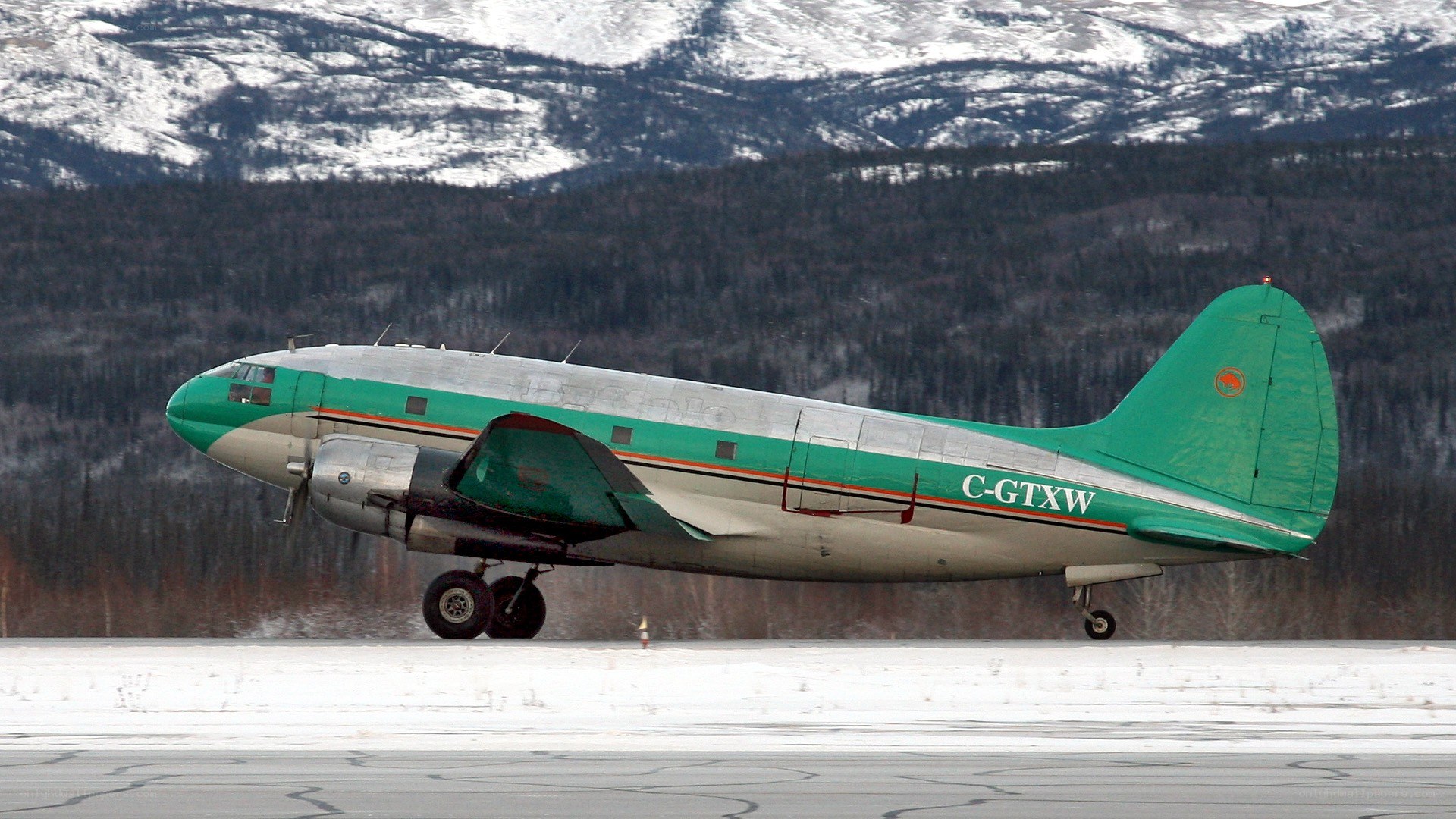 Green and silver airplane on runway