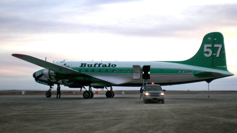 Green and white airplane on tarmac