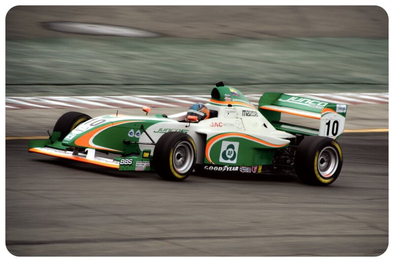 green and white race car on track
