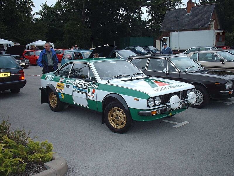 Green and white rally car at event