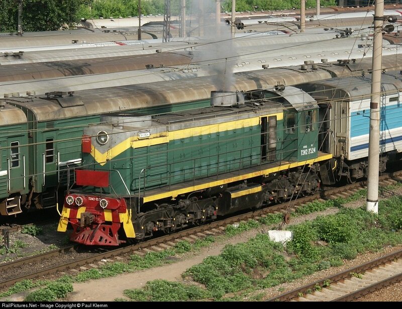 Green and yellow locomotive on tracks
