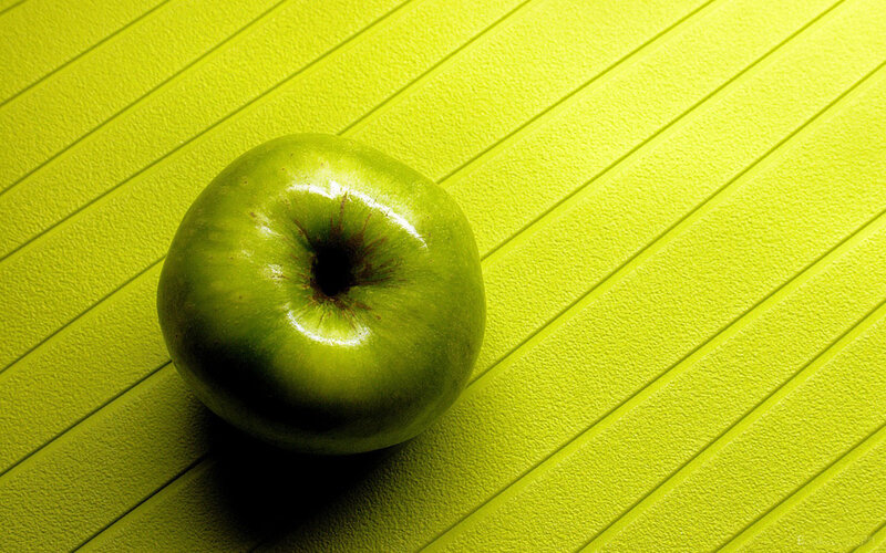 green apple on yellow surface