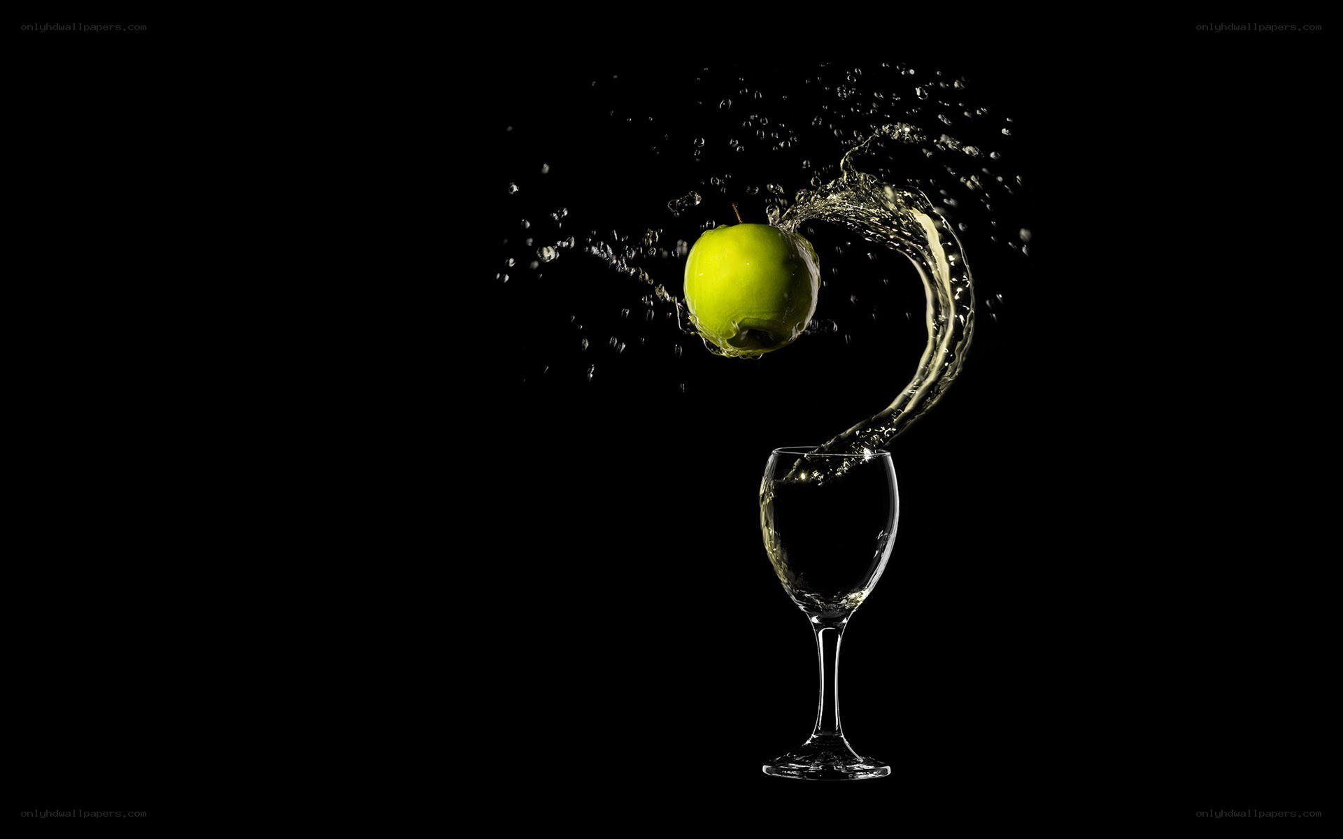 green apple splashing into glass