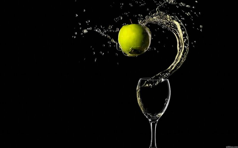 green apple splashing into wine glass