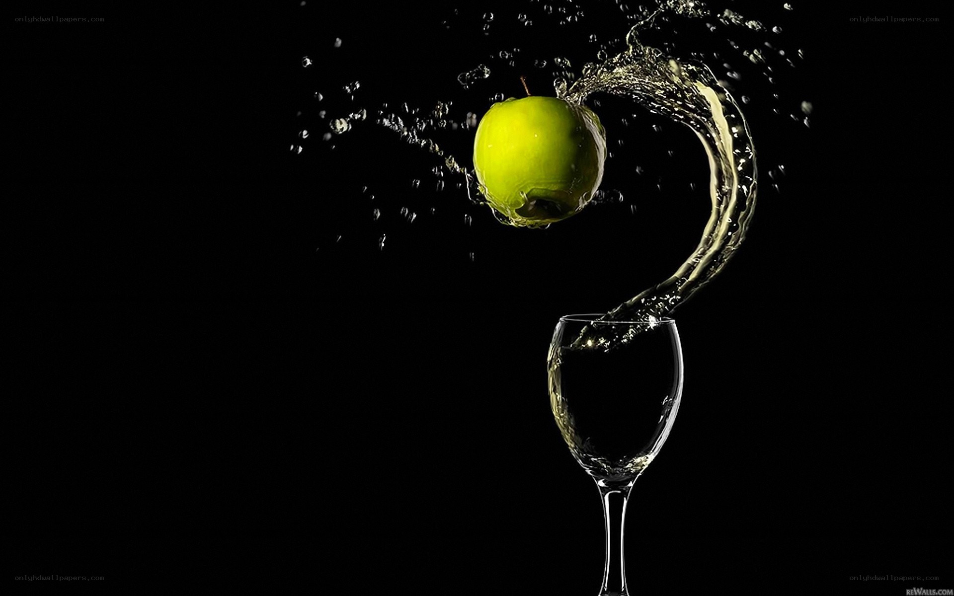 green apple splashing into wine glass