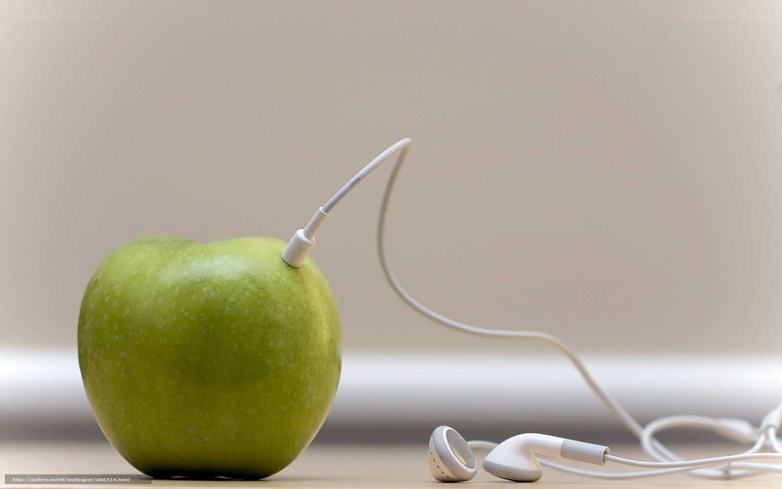 green apple with earbuds