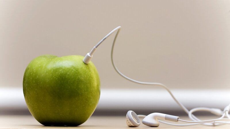 green apple with earbuds