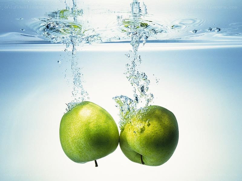 green apples falling into water