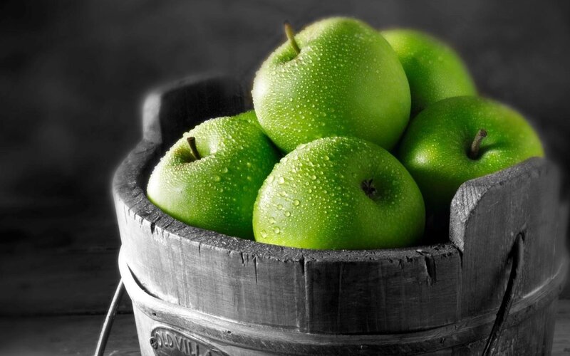 Green apples in a wooden bucket