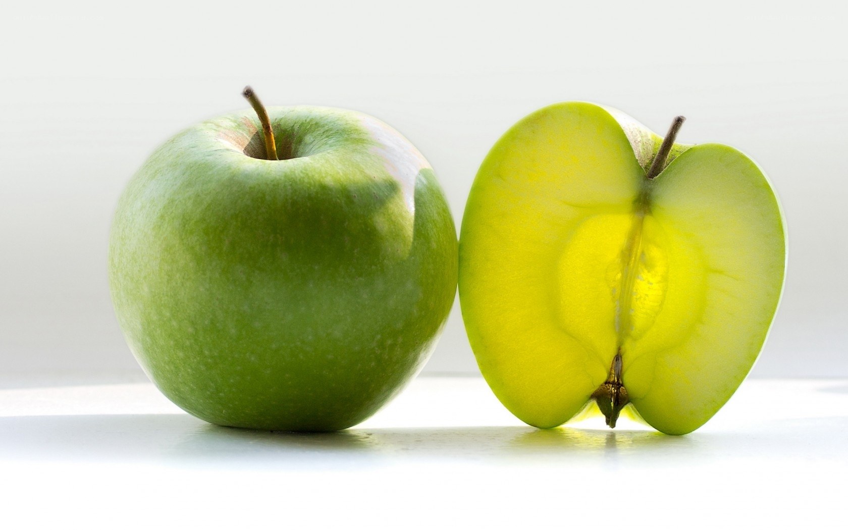 Green apples on white surface