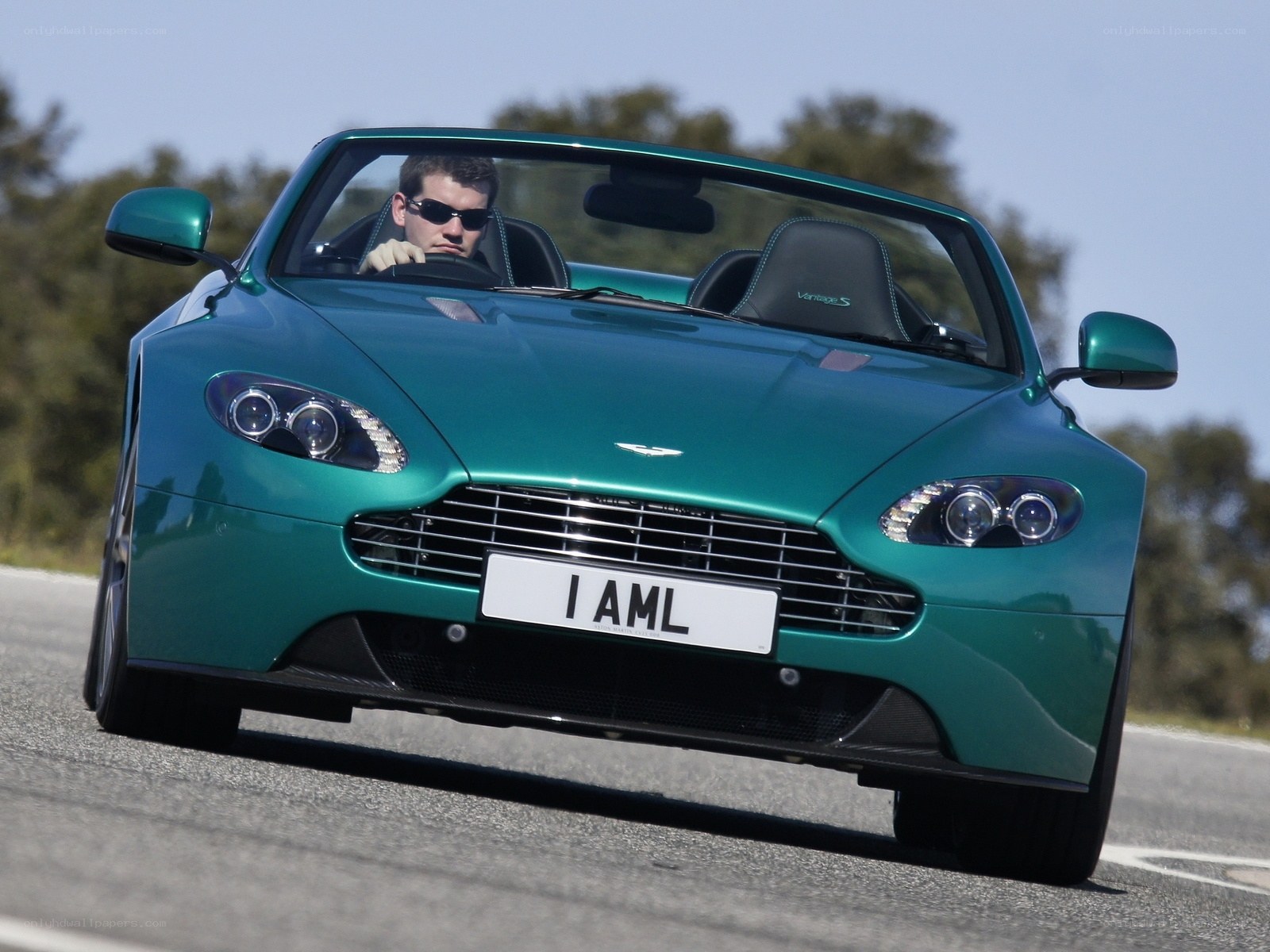 Green Aston Martin driving on road