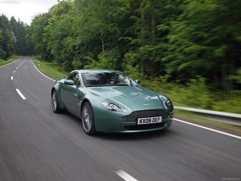 Green Aston Martin on a forest road
