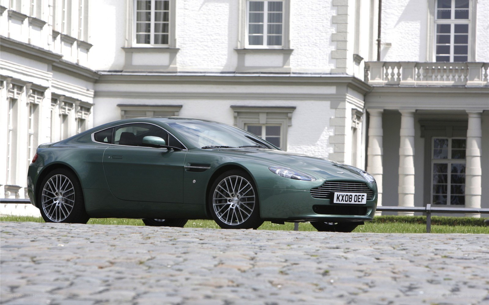Green Aston Martin on cobblestones