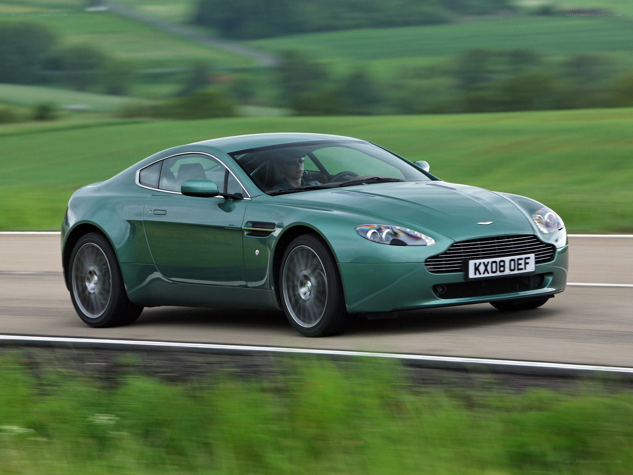 Green Aston Martin on country road