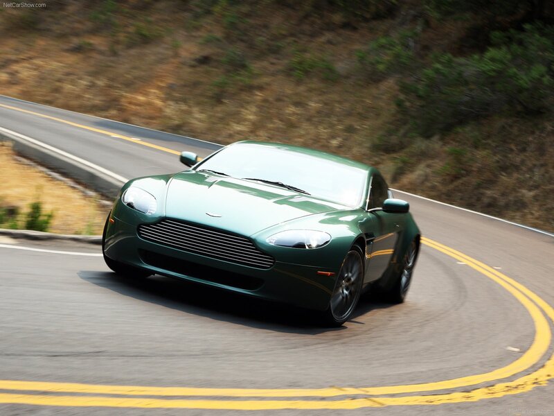 green aston martin on winding road