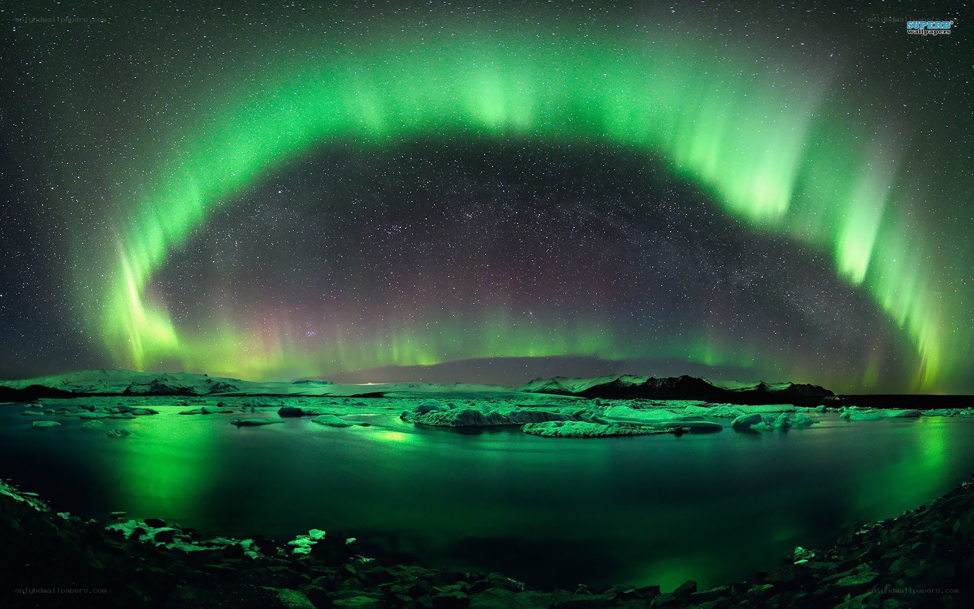 Green aurora over icy landscape