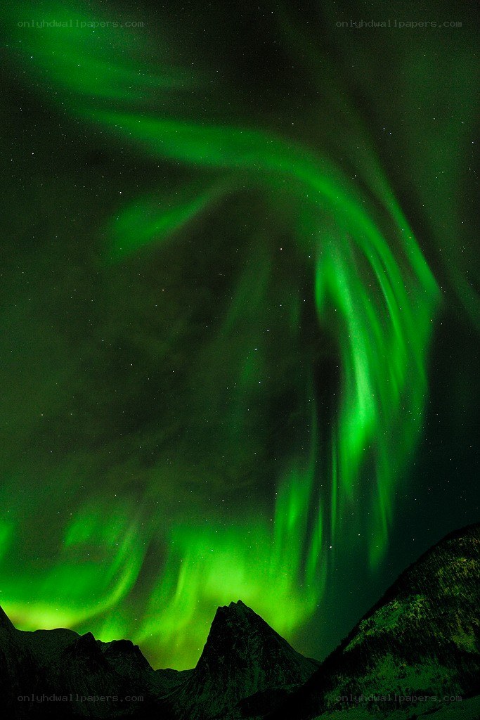 Green aurora over mountains