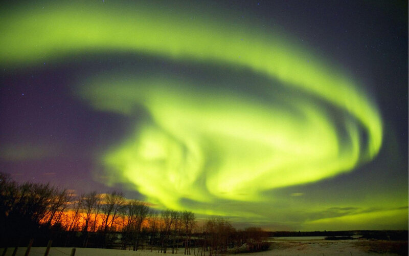 Green aurora over snowy landscape