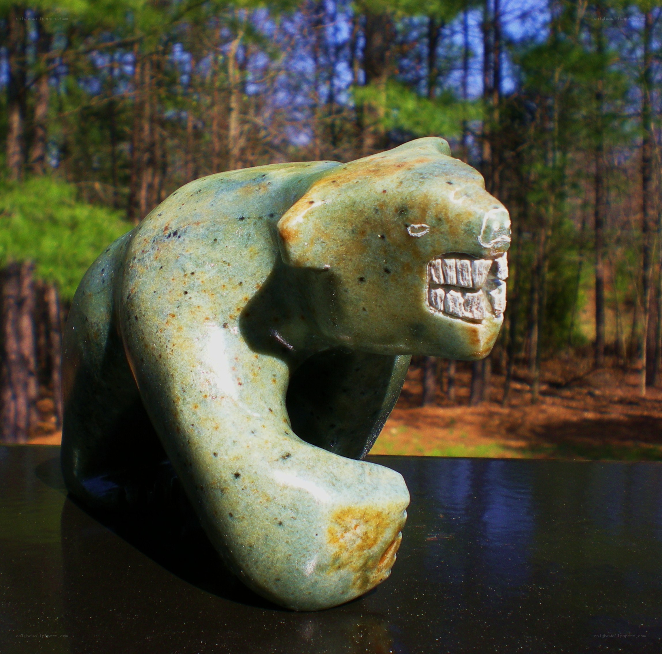 Green bear sculpture in forest