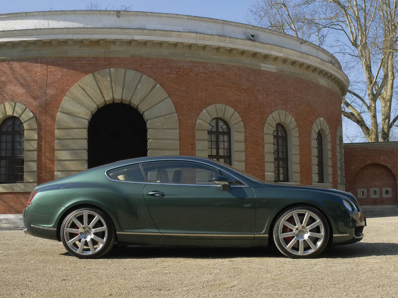 Green Bentley coupe in front of building