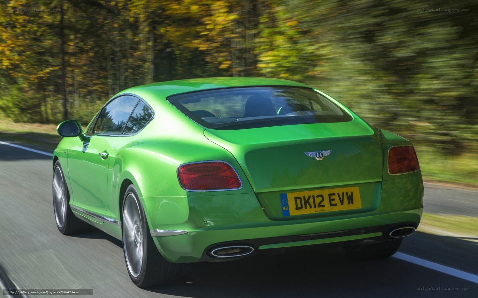green bentley driving on road