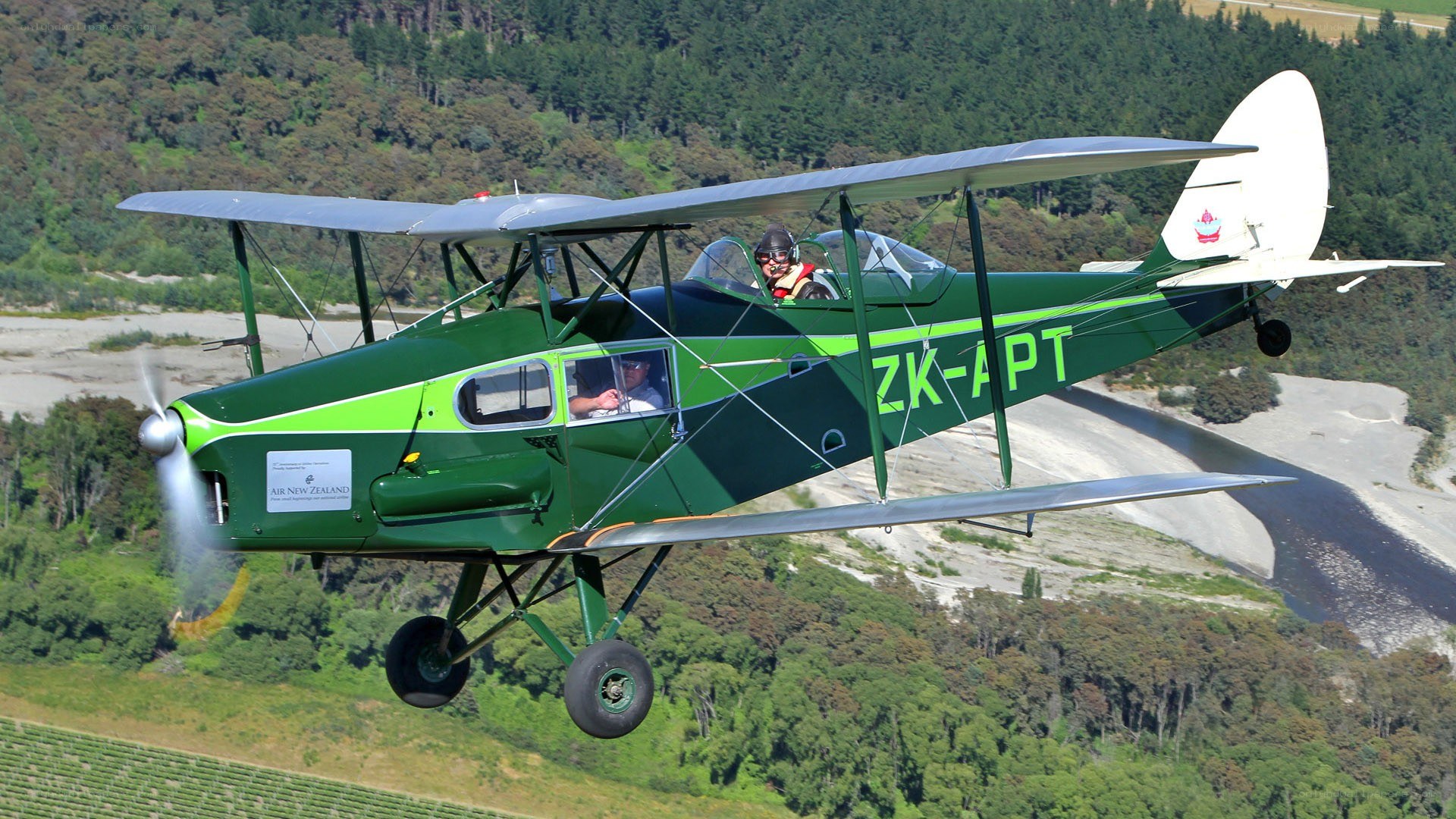 Green biplane in flight